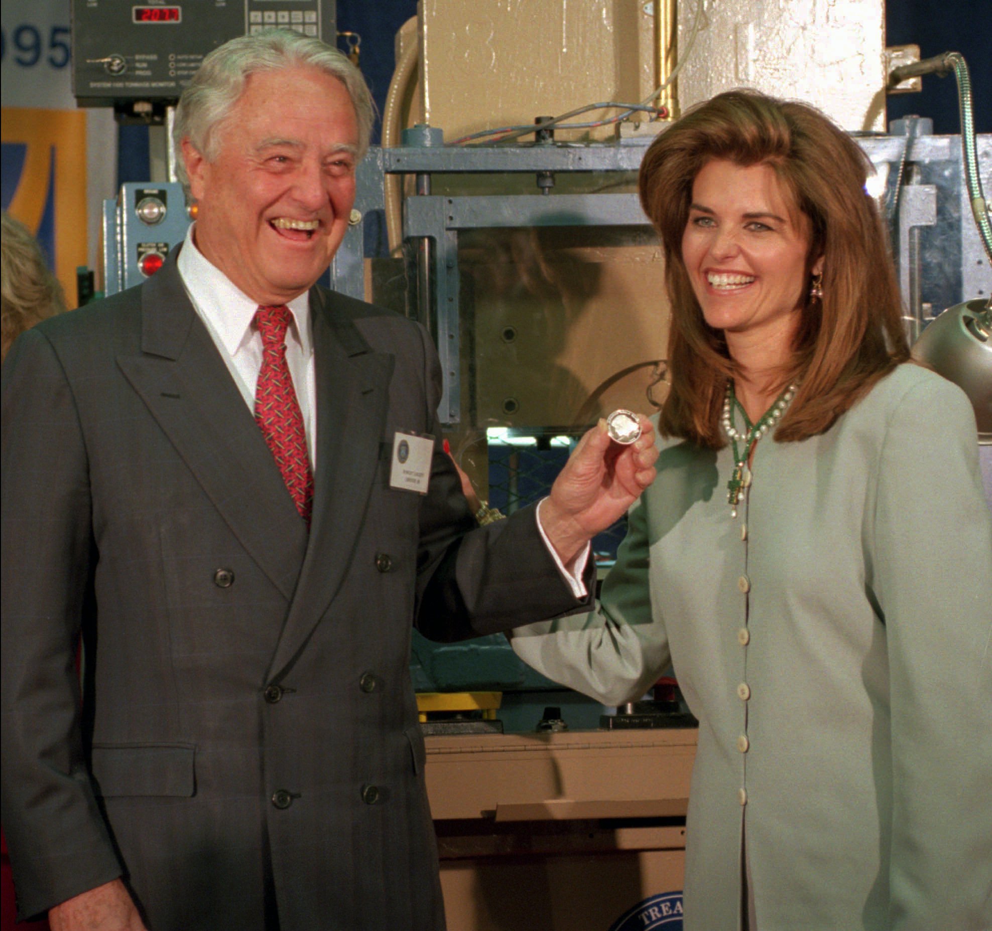 R. Sargent Shriver and his daughter, Maria, hold a newly minted commemorative silver dollar coin honoring his wife, Eunice Kennedy Shriver, at the U.S. Mint in Philadelphia, in 1995. (Nanine Hartzenbusch/AP)