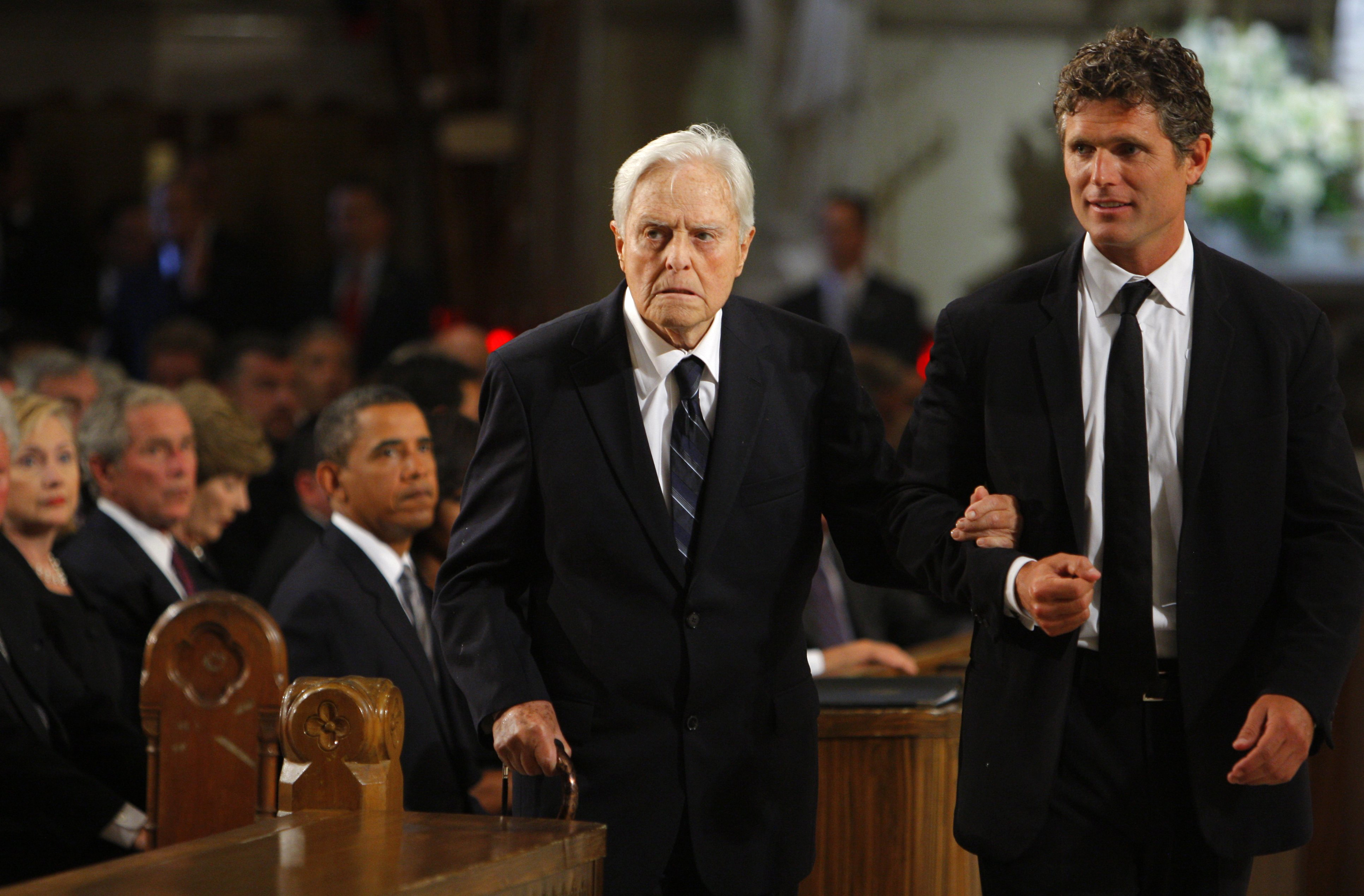 R. Sargent Shriver, left, is escorted to his seat his son, Anthony Kennedy Shriver, before funeral services for Sen. Edward M. Kennedy in August 2009. (Pool photo by Brian Snyder via AP)