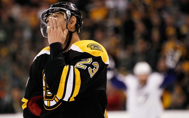 Boston Bruins' Chris Kelly wipes his face as a Tampa Bay Lightning player celebrates a goal during Game 1 of the Eastern Conference finals. (AP)